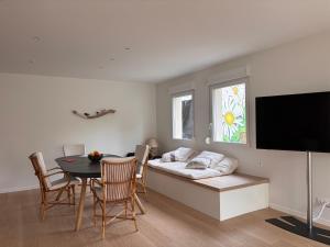 a living room with a bed and a table and chairs at Appartement Les Marguerites spa et spa de nage in Contrexéville