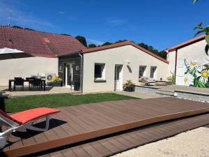 a backyard with a wooden deck and a house at Appartement Les Marguerites spa et spa de nage in Contrexéville