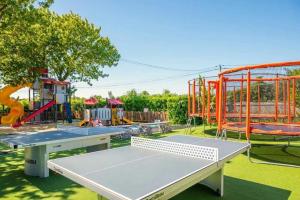 a playground with two tables and a swing at Camping 4 étoiles - Parc aquatique - eeiaia in Olonne-sur-Mer