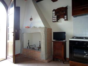 sala de estar con chimenea y TV en Casa Roffi Esposito, en Pieve di Santa Luce