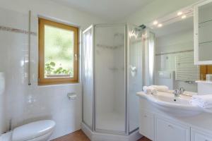 a bathroom with a shower and a toilet and a sink at Villa Bernhard in Siusi