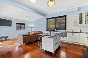 eine offene Küche und ein Wohnzimmer mit einem Sofa in der Unterkunft South Freo Bungalow - Hidden Spa Bath in South Fremantle