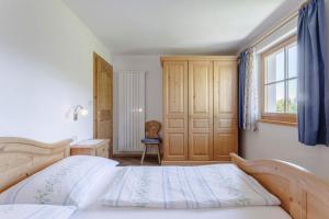 a bedroom with a large bed and a window at Villa Bernhard in Siusi
