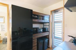 a kitchen with a black cabinet with a microwave at 阿蘇ビューテラス in Aso