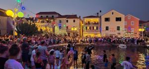 a crowd of people standing on the edge of a river at Apartment Pelicaric Sali Dugi otok in Sali