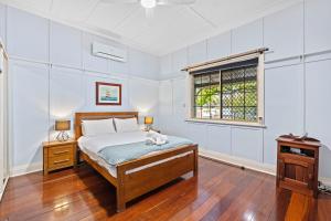 ein Schlafzimmer mit einem Bett, auf dem eine Katze liegt in der Unterkunft South Freo Bungalow - Hidden Spa Bath in South Fremantle