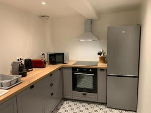 a kitchen with a refrigerator and a stove top oven at Maison authentique en bord de Meuse in Joigny-sur-Meuse