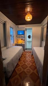 a room with two beds and a tv in a room at Casa Janela Azul in Belém