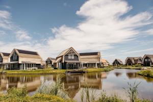 una fila di case vicino a un corpo d'acqua di Watervilla buitenzijde | 6 personen a Heeg