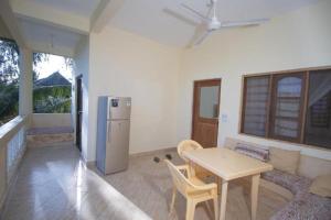 a living room with a table and a refrigerator at GK Palm Resort Watamu in Watamu