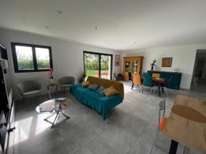 a living room with a couch and a table at Le gîte des Acacias in Montech