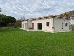 a small white house with a large yard at Le gîte des Acacias in Montech