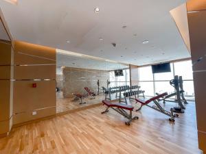 einen Fitnessraum mit Laufbändern und Heimtrainern in einem Zimmer in der Unterkunft StayShort - Spacious Carson C Studio in Damac Hills in Dubai Marina