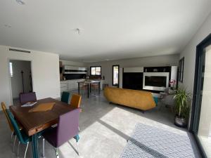 a living room with a table and a dining room at Le gîte des Acacias in Montech