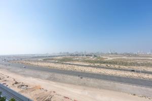 eine leere Autobahn mitten in einer Wüste in der Unterkunft StayShort - Spacious Carson C Studio in Damac Hills in Dubai Marina + 32 Fotos