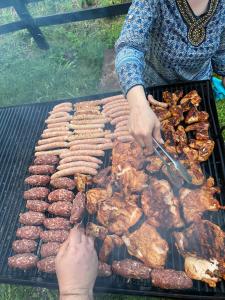 瓦特拉多尔内Pensiunea Tora的在烤架上烤肉和香肠的人