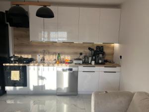 Wiejska Przystań Bory Tucholskie的配有白色橱柜和台面的厨房