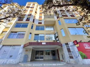 un edificio alto con la sua facciata di Quarteira Central 3 by Homing a Cavacos