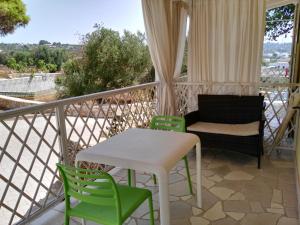 a balcony with a table and chairs and a couch at B&B Lu Cantoru in Marina di Pescoluse