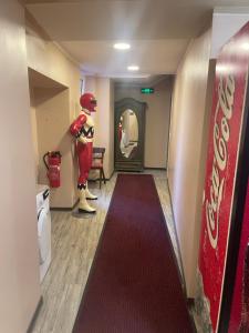 a hallway with a mannequin standing next to a red carpet at LIVI Hostel und Pension in Dortmund +7 photos