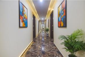 a hallway with a tile floor and paintings on the walls at Via Corinthia Boutique Rooms - Nr Candolim Beach in Candolim