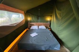 a bedroom with a bed in a green tent at Camping 3 étoiles - Piscine - eebebg in Guéméné-Penfao +206 photos