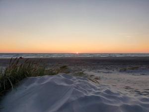 ein Sonnenuntergang am Strand mit einem Sandhaufen in der Unterkunft 6 person holiday home in Hirtshals-By Traum in Hirtshals