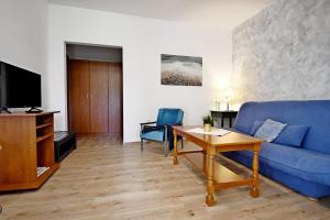 a living room with a blue couch and a table at apartmani Novotny crveni in Banjol