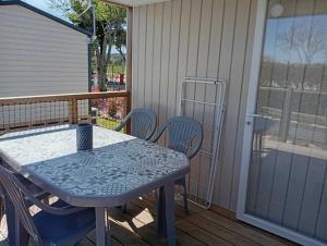 une table et des chaises sur une véranda grillagée avec une table et des chaises dans l'établissement Chalet 3 étoiles - Piscine - eebicc, à Massillargues-Attuech