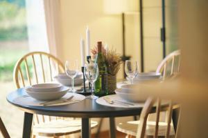 a dining room table with plates and wine glasses at 阿蘇ビューテラス in Aso