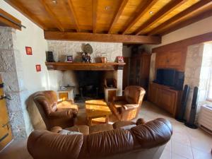 Elle comprend un salon doté d'un mobilier en cuir et d'une cheminée. dans l'établissement La maison des lieux, à Fauroux