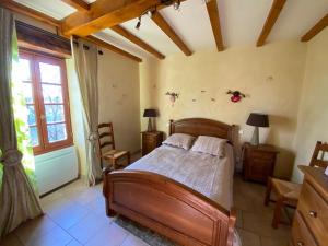 une chambre avec un lit en bois et une fenêtre dans l'établissement La maison des lieux, à Fauroux