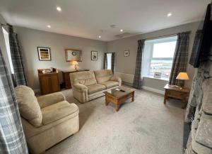 ein Wohnzimmer mit zwei Sofas und einem Tisch in der Unterkunft Chandlers BnB in Seahouses