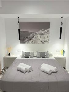 Un dormitorio con una cama grande con dos almohadas. en Fira Basement Studios, en Santorini