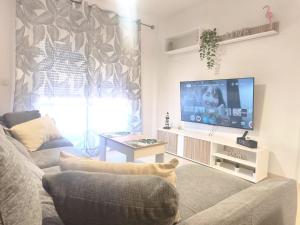 ein Wohnzimmer mit Couch und Flachbildfernseher in der Unterkunft Las Palmeras in Matalascañas