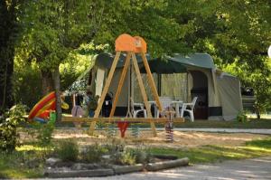 ein Park mit Zelt und Spielplatz in der Unterkunft Camping 3 étoiles - Piscine - ccbb0if in Montpon-Ménestérol
