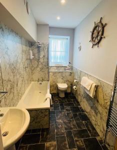 ein Badezimmer mit Badewanne, Toilette und Waschbecken in der Unterkunft Chandlers BnB in Seahouses