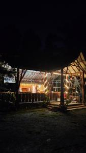 Un edificio iluminado con luces por la noche. en Hide and Seek, en Tetebatu