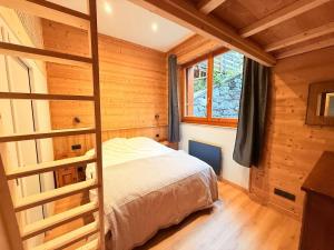 a bedroom with a bed in a wooden cabin at Chalet école des cimes in Bozel