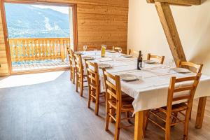 a long table in a room with a large window at Chalet école des cimes in Bozel