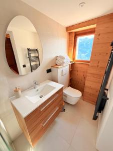 a bathroom with a sink and a mirror and a toilet at Chalet école des cimes in Bozel +72 photos