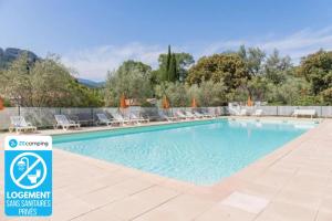 - une piscine dans un complexe avec des chaises dans l'établissement Camping 3 étoiles - Piscine - cbgcaia, à Buis-les-Baronnies