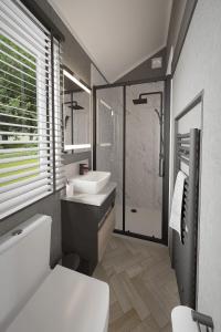 une salle de bain avec une baignoire, un lavabo et une douche dans l'établissement The Hideaway Sleeps 6 at Thurston Manor Park B, à Innerwick