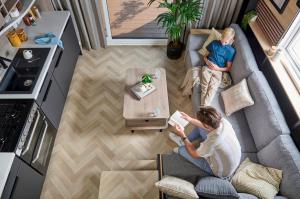 2 personnes assises sur un canapé dans un salon dans l'établissement The Hideaway Sleeps 6 at Thurston Manor Park B, à Innerwick