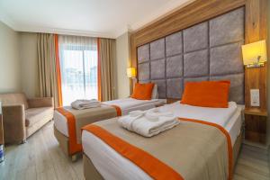 ein Hotelzimmer mit zwei Betten und einer Couch in der Unterkunft grand Şeker hotel in Side