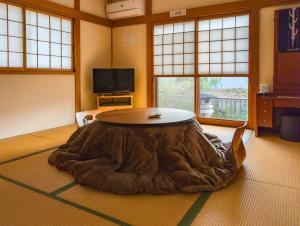 a living room with a table with a large brown circle around it at ゲストハウス634庵 in Sango