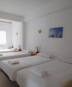 a white room with three beds and a picture on the wall at Apartaments Els Avets in Pas de la Casa