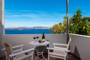 a table with two glasses of wine on a balcony at Acrothea Suites and Villas - Akrotiri Caldera - Santorini in Akrotiri