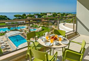 un balcon avec une table et des chaises et une piscine dans l'établissement Alfagar Prestige, à Albufeira