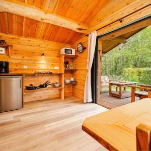 une cabane en bois avec une cuisine et un patio dans l'établissement Camping 3 étoiles - Piscine - ccafbbc, à Huelgoat